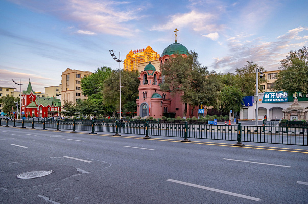 Общий вид на здание евангелически-лютеранской кирхи и Свято-Покровскую церковь с Дундачжи цзе (бывшего Большого проспекта). Сентябрь 2024. Фото Елизаветы Кириной